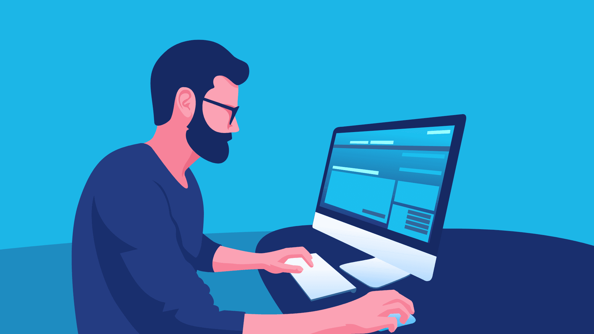 An IT guy with glasses working on his computer.